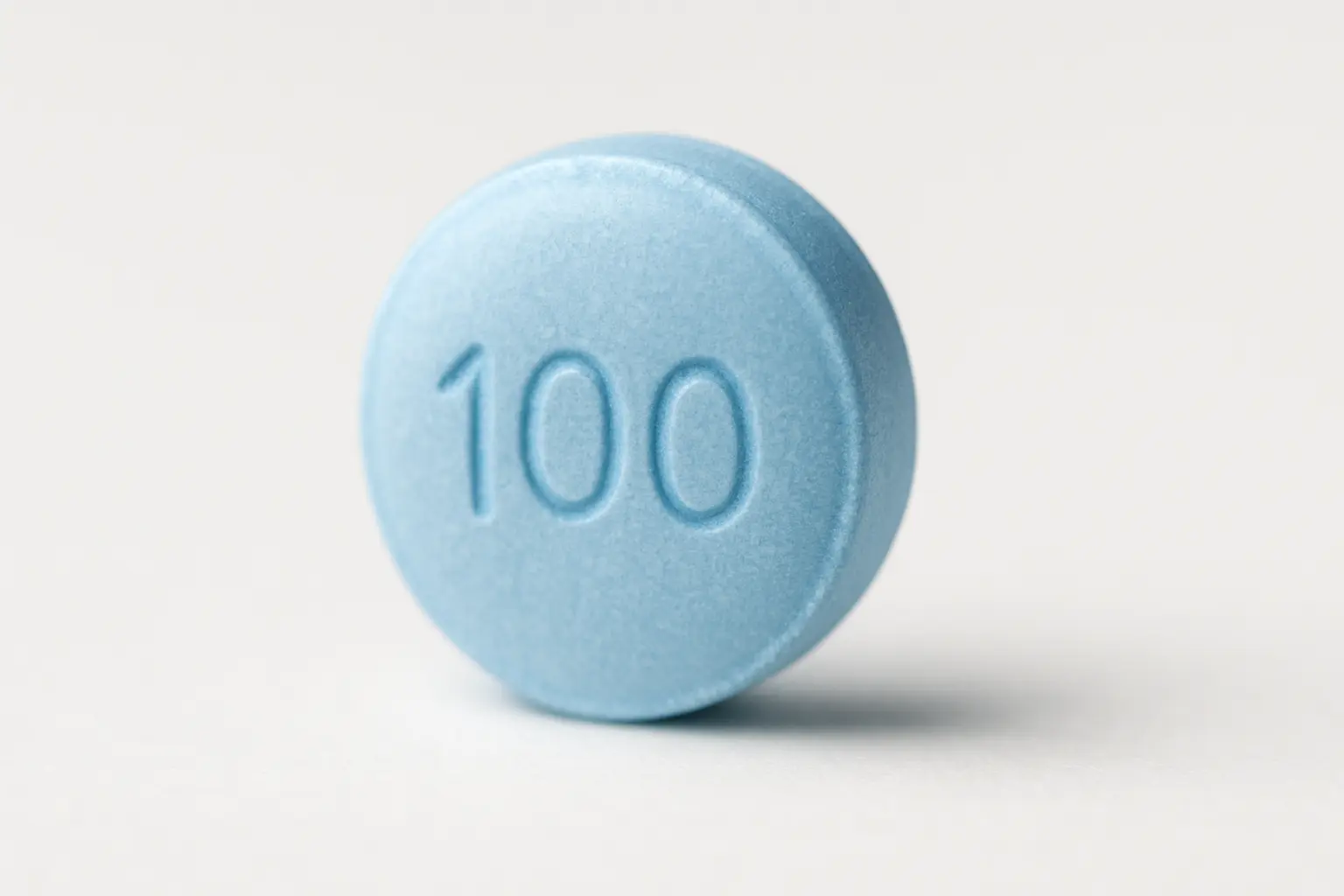 A detailed macro shot of a blue Cenforce 100 mg Sildenafil tablet.